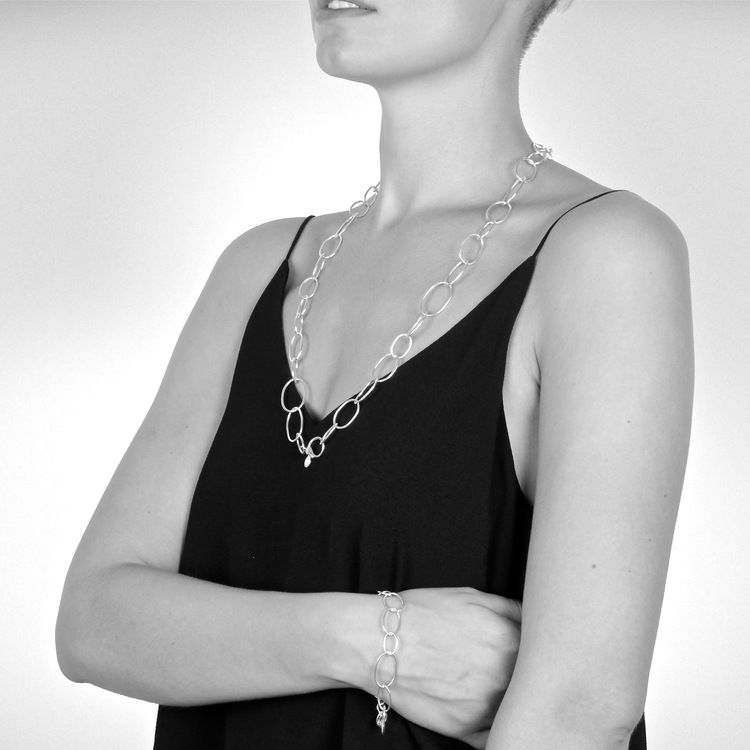 långt silverhalsband med runda länkar i olika storlekar. long silver chain with round links in various sizes.