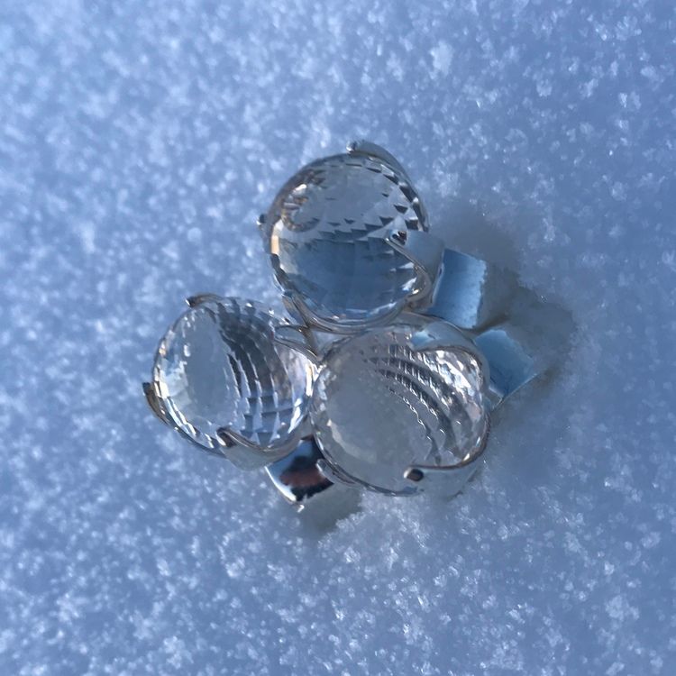 stora silverringar med facettslipade bergskristaller stående i snö. big silver rings with crystal quartz standing in snow