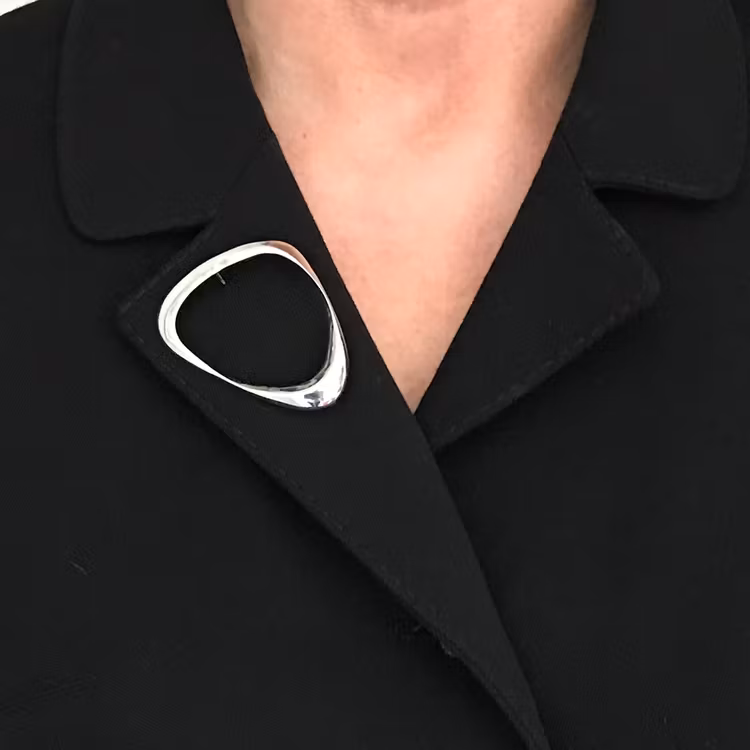 silverbrosch på en svart kavaj, silver brooch on a black jacket