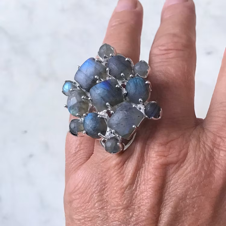 Stor silverring med mattslipad labradorit i olika toner av blått och turkost. Big silver ring with mat polished labradorite in various tones of blue and turquoise