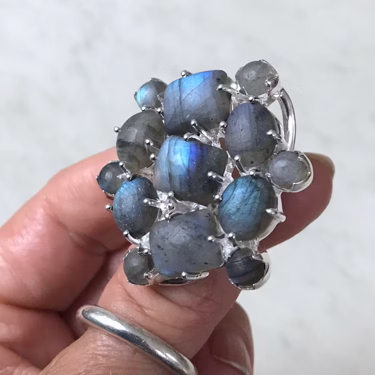 Stor silverring med mattslipad labradorit i olika toner av blått och turkost. Big silver ring with mat polished labradorite in various tones of blue and turquoise