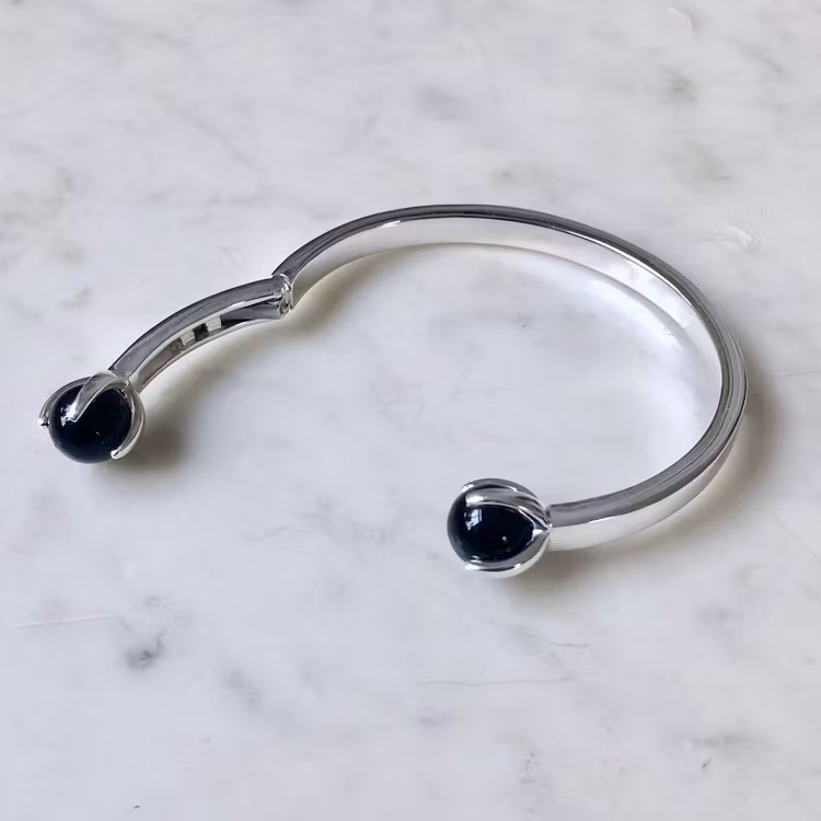 Silverarmband med vacker svart onyx, lätt att sätta på med fjädrande gångjärn. Silver bracelet with beautiful black onyx, easy to put on with a hinge