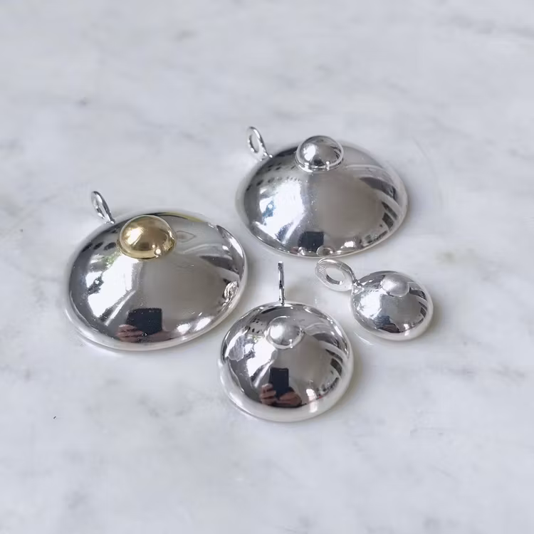 Silverhängen i form av hängbröst, i tre olika storlekar. Silver pendants in three sizes
