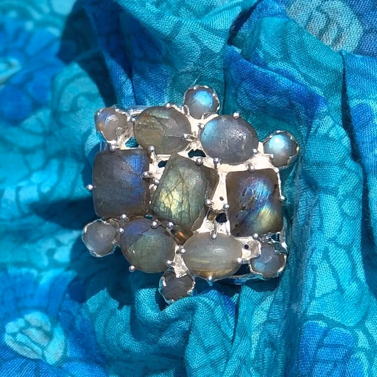 Stor silverring med mattslipad labradorit i olika toner av blått och turkost. Big silver ring with mat polished labradorite in various tones of blue and turquoise