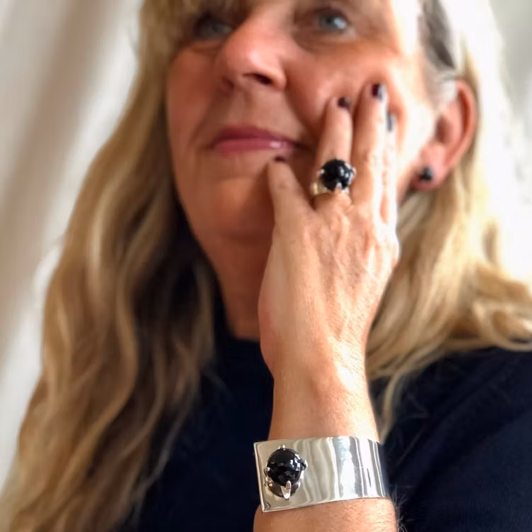 Kvinna med stor silverring och silverarmband med rökkvarts. Woman with big silverring and silver bracelet with smokey quartz.