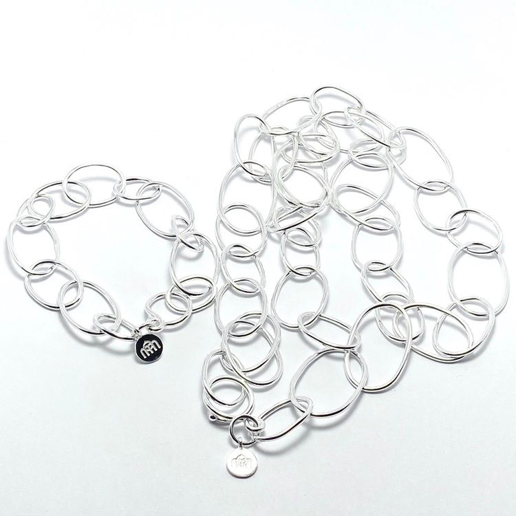 silverarmband gjort av öglor i olika storlekar och matchande halsband. silver bracelet with round links and matching necklace