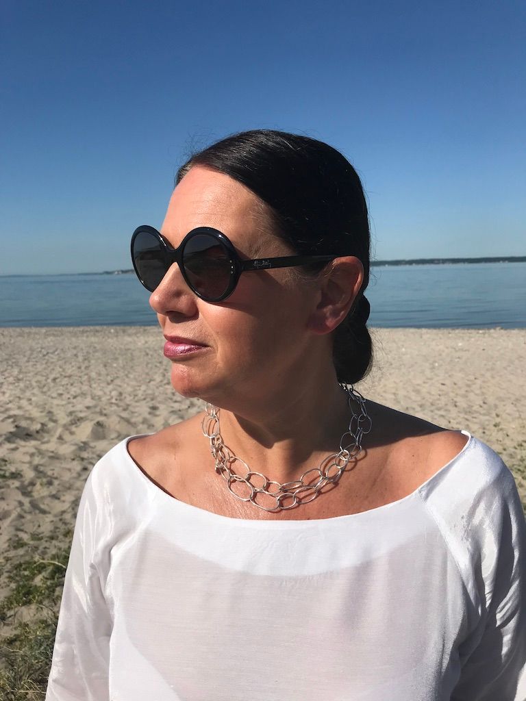långt silverhalsband med runda länkar i olika storlekar. long silver chain with round links in various sizes.