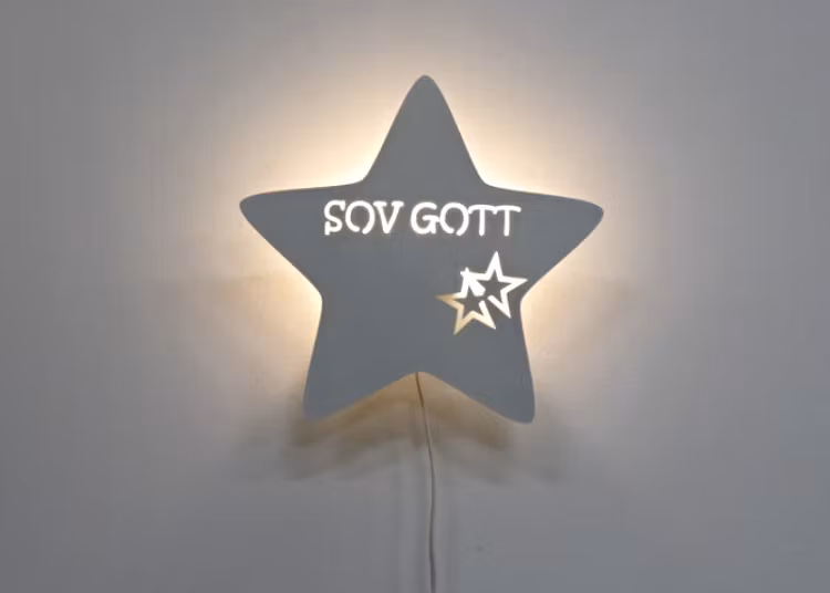 Stjärnformad vägglampa med texten SOV GOTT