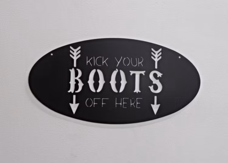 Oval skylt med texten "kick your BOOTS off here".