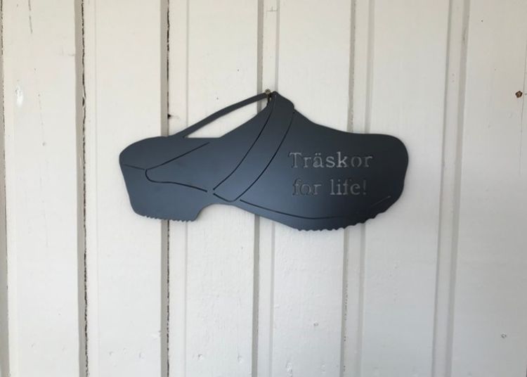 Svart träsko i plåt med texten "Träskor for life".