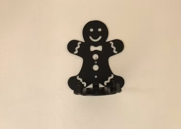 Väggljushållare i form av en pepparkaksgubbe i plåt.