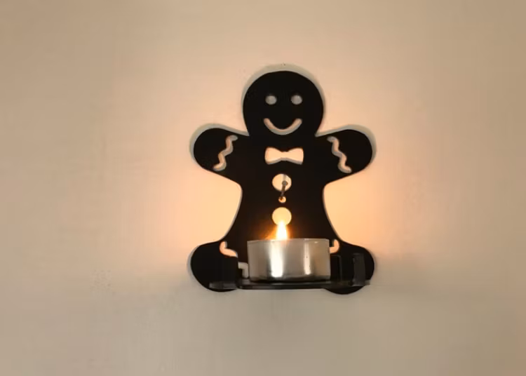 Svart pepparkaksgubbe i plåt som ljushållare.