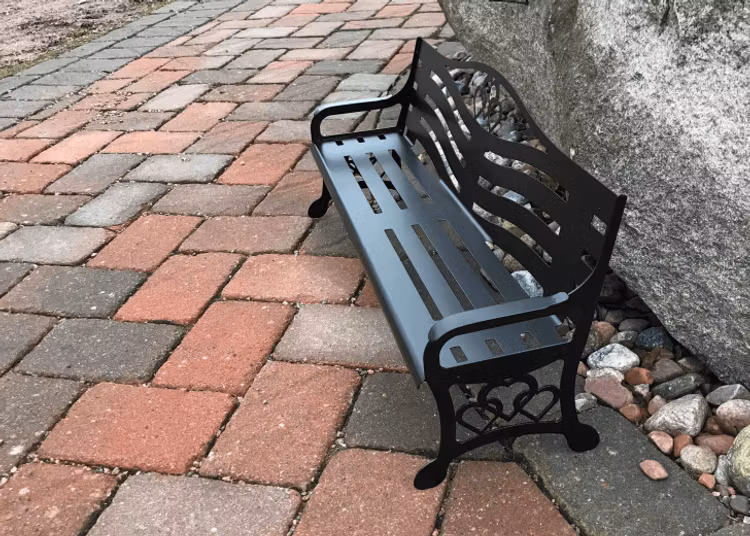 Liten parkbänk i plåt.