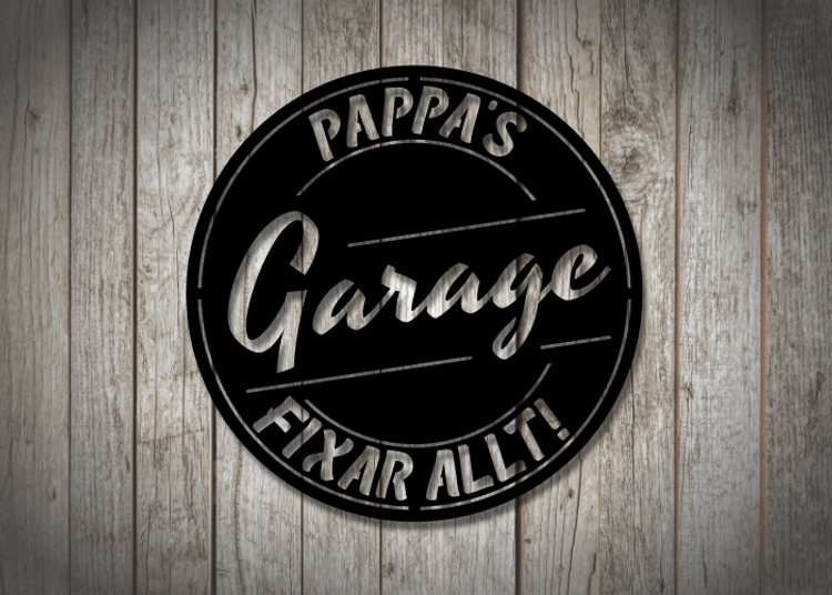 Svart garageskylt i metall mot träfasad.