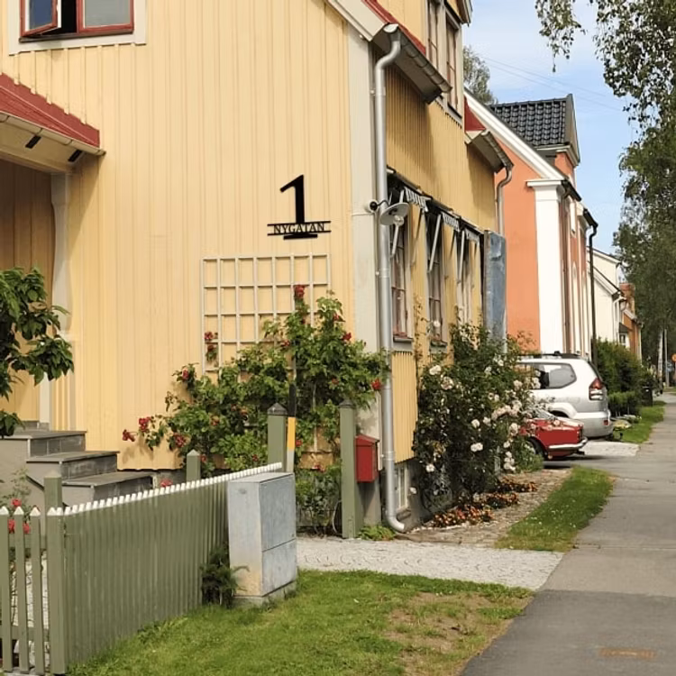 Stilren fasadsiffra med gatunamn.
