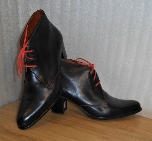 Svart känga med orange snören - fabrikat Amberone