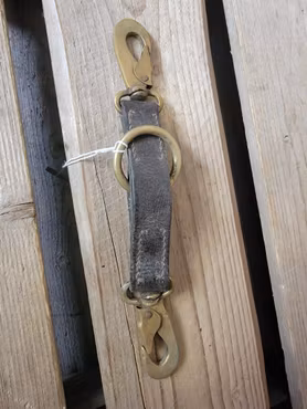 Delta i brunt läder med mässingspännen