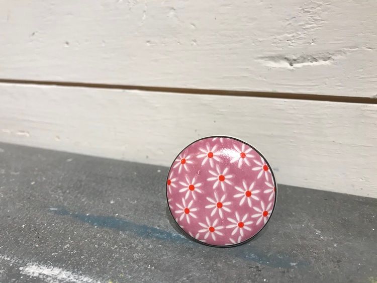 Rosa och vit keramikknopp med blommor.