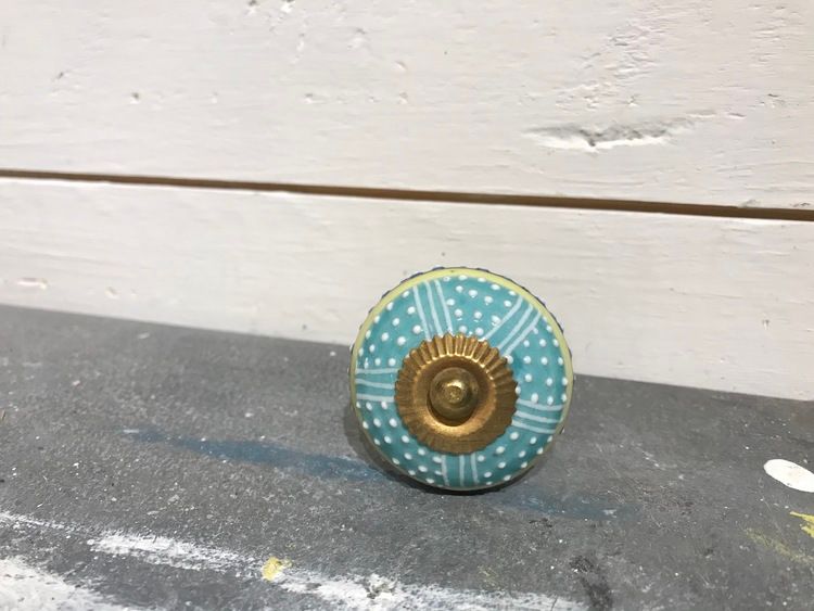 Turkos knopp med ränder och prickar