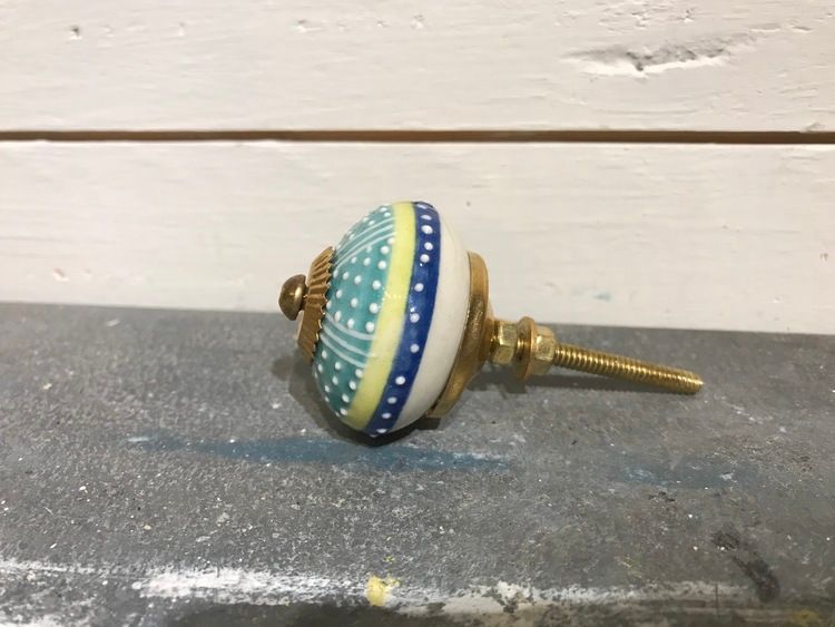 Turkos knopp med ränder och prickar