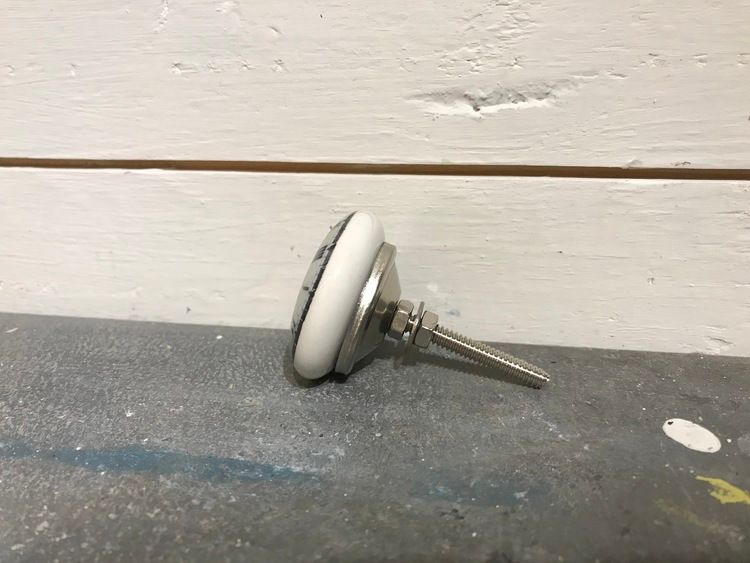 Vit keramikknopp med klocka på framsidan.