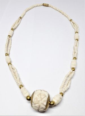 Halsband i ben med kulor i gul metall