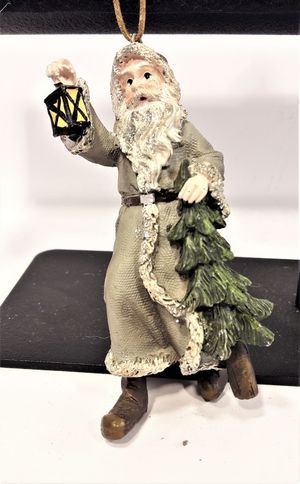 Prydnadsfigur att hänga, tomte med stav och gran. Detaljfull och dekorativ. Med snöre.