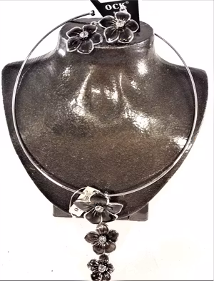 Stelt halsband med hänge av svarta blommor samt matchande örhängen