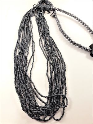 Långt halsband med stora och små pärlor i grått