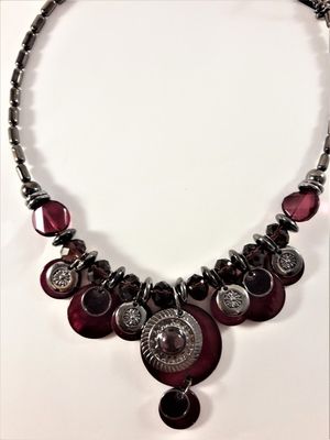 Detaljrikt halsband med många detaljer i lila och silverfärg