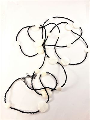 Långt halsband med svarta pärlor och vita snäckskal