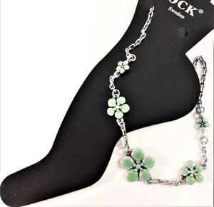 Fotlänk med gnistrande stenar och fina gröna blommor, silverfärgad kedja