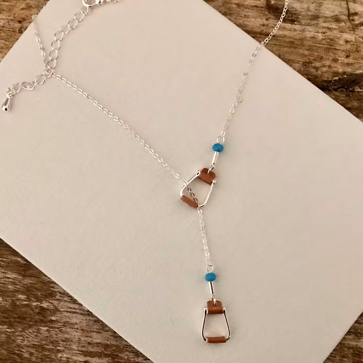Bild på halsband med stigbyglar och turkosa pärlor