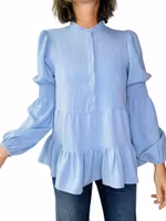 Ljusblå blus med volanger