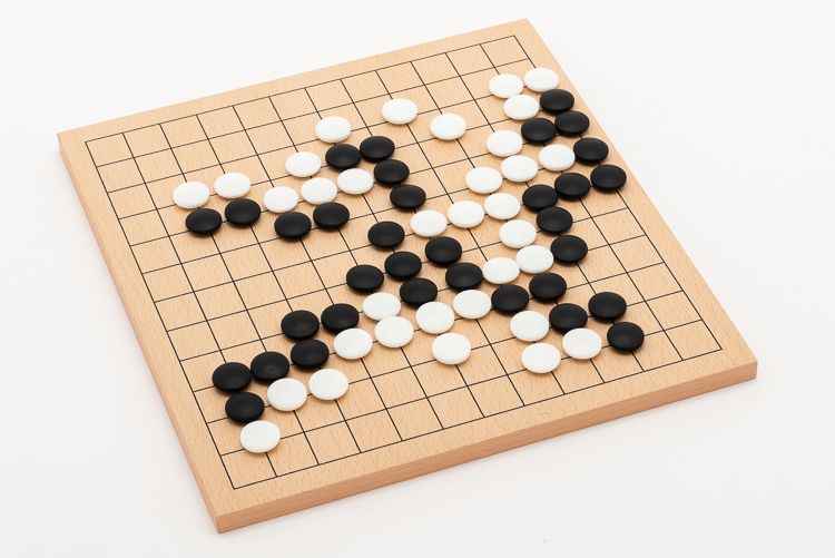 Go-parti med glasstenar på mellanstort bräde. Trivia: andra namn för Go är Baduk, Weiqi och Igo.