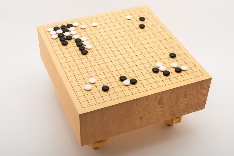 Pågående parti med snäckskalsstenar på tjockt golvbräde, ett så kallat Goban. Tillverkat av shinkaya i Korea.