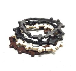 Armband med kors i polystone med elastiskt band. Art.nr: H 02002. Färg: Grå.