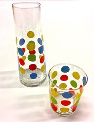 Dots en en glaskaraff och glas med blå, gröna, gula, röda och oranga prickar.
