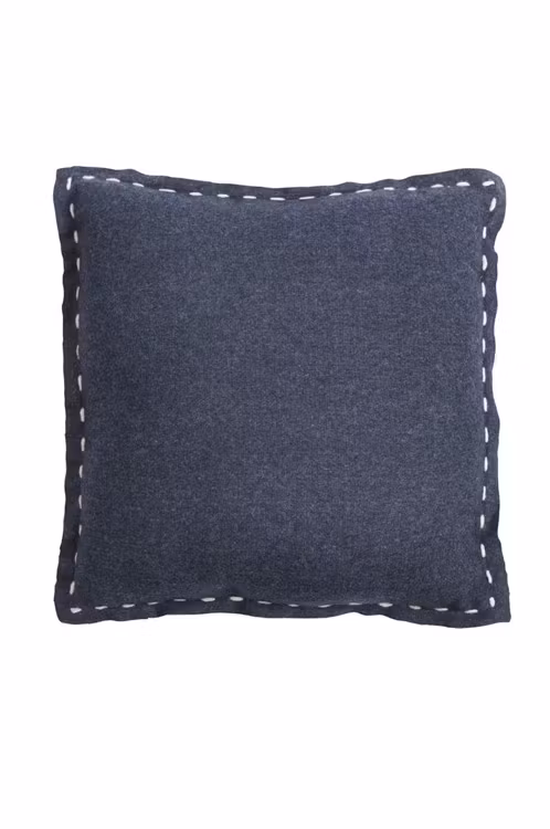 Moa wool en svart prydnadskudde med vita kantstickningar från Noble house.