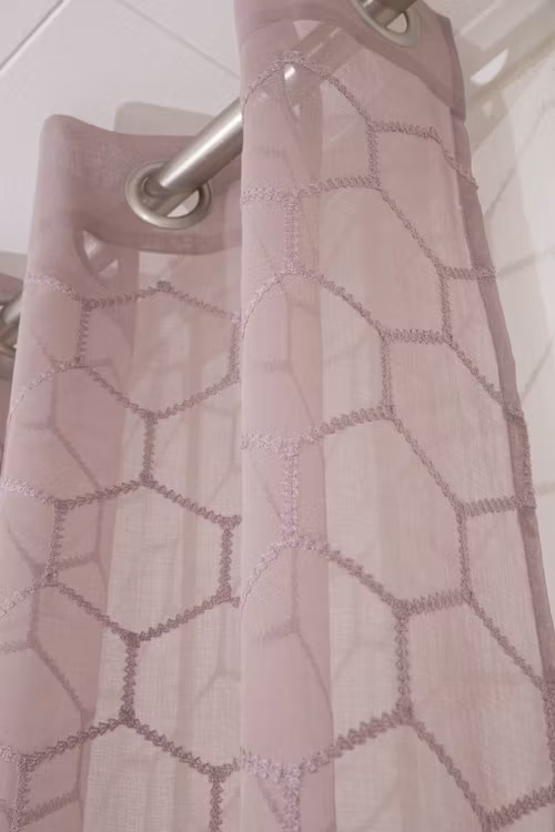 Aline ett gardinset med öljetter. Färg: Ljung.