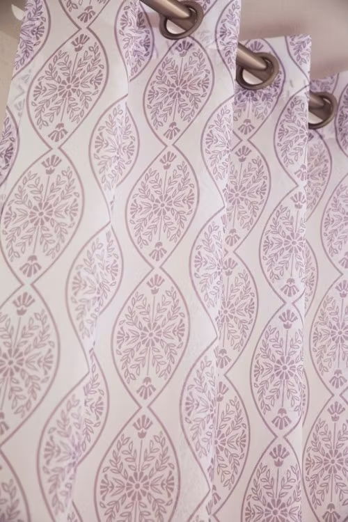 Fox ett gardinset i vitt med ett rosa mönster med öljetter från Svanefors.