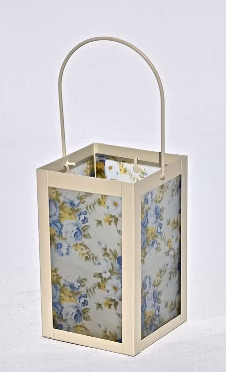 Lykta Blå rosor. Färg: En cremefärgad lykta med vitt glas med blå rosor och gröna blad.
