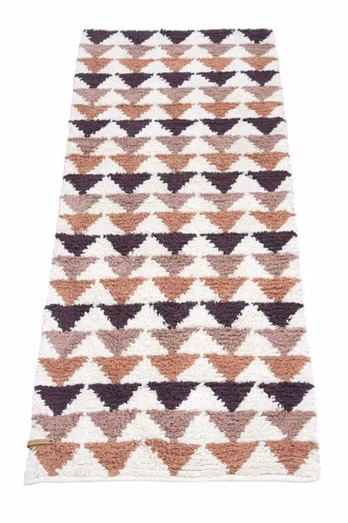 Tripple är en rosa, plommon, rost och vit gång/ryamatta med ett grafiskt mönster med trekanter i mått 70 x 200 cm.