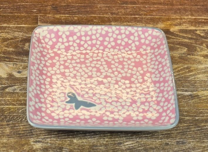 Butterfly en rosa fyrkantig assiett med en grå fjäril och kant i rosa, grå och vit.