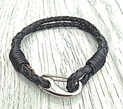 Armband med ett dubbelt flätat läderband och en karbinhake i stål. Art.nr 2023. Färg: Svart och stål.