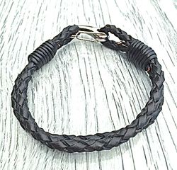 Armband med ett dubbelt flätat läderband och en karbinhake i stål. Art.nr 2023. Färg: Svart och stål.
