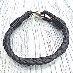 Armband med ett dubbelt flätat läderband och en karbinhake i stål. Art.nr 2023. Färg: Svart och stål.