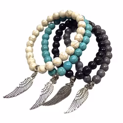 Armband med pärlor och en metallberlock med en fjäder och elastiskt band. Art.nr: H 02007. Färg: Off-white.