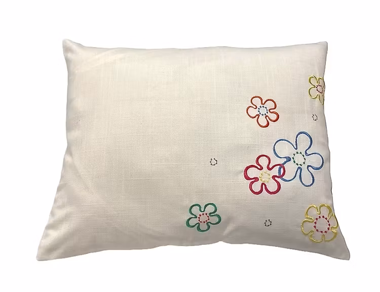 Kuddfodral i bomull med broderade blommor. Färg: Vitt med broderade blommor i gult, rött, orange, grönt och blått..