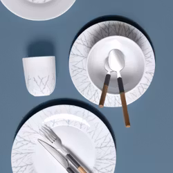 Björk en tallrik från modern house i vitt med grå dekor.